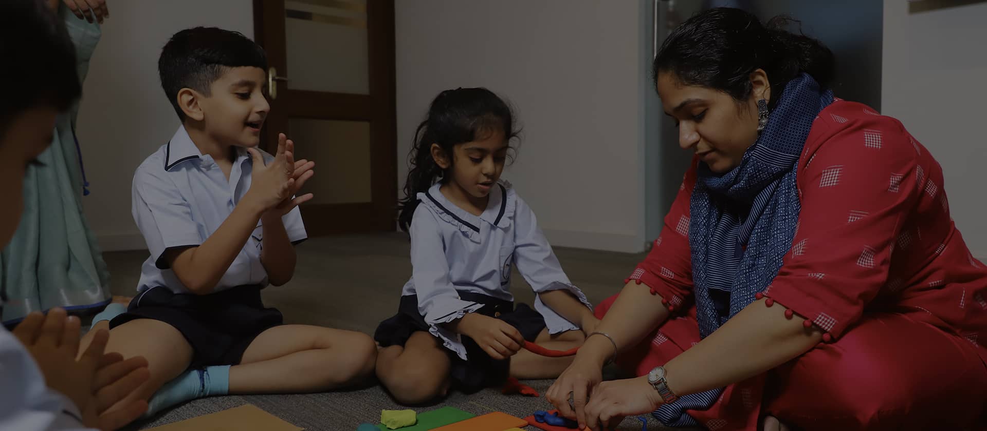 Children and teacher playing with clay